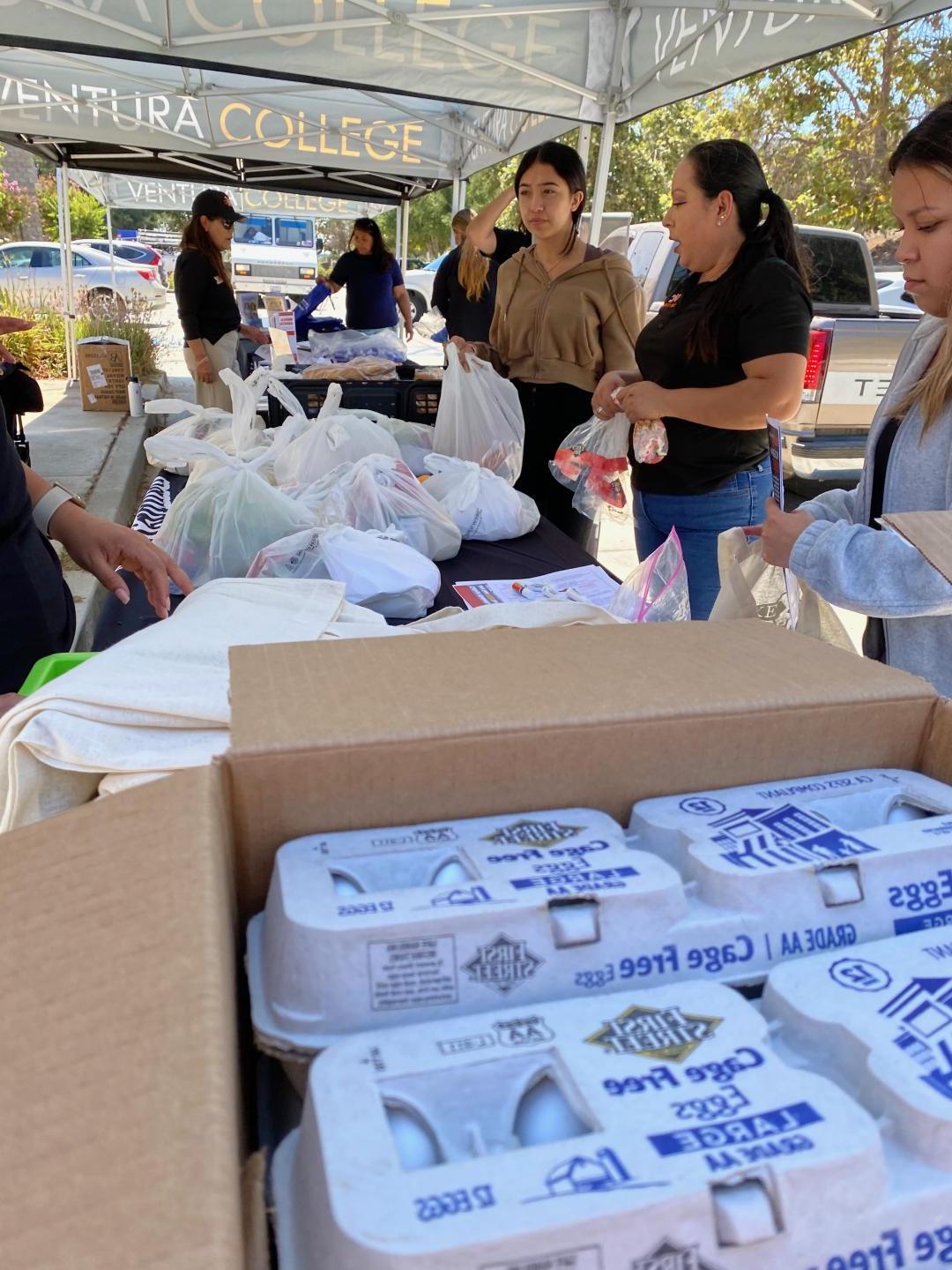 Students receiving free groceries such as eggs, bread and dry goods.